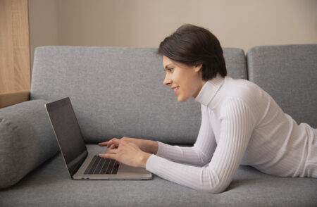 young woman using laptop on a couch